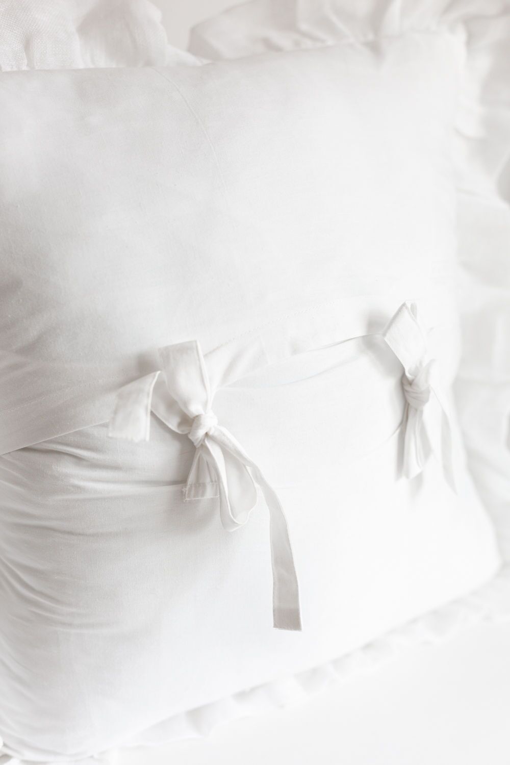 Close-up of white bedding with fabric tie closures on a duvet cover